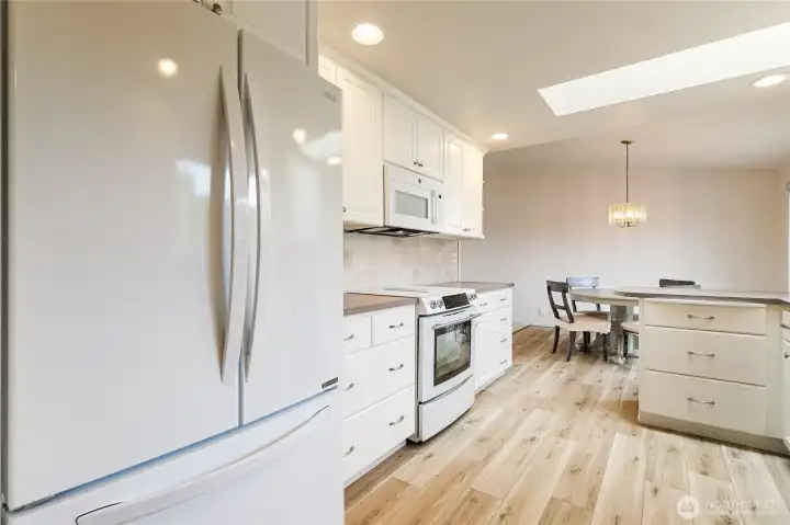 LVP flooring throughout the entrance, hallway into the kitchen and dinning room leading to the backyard.