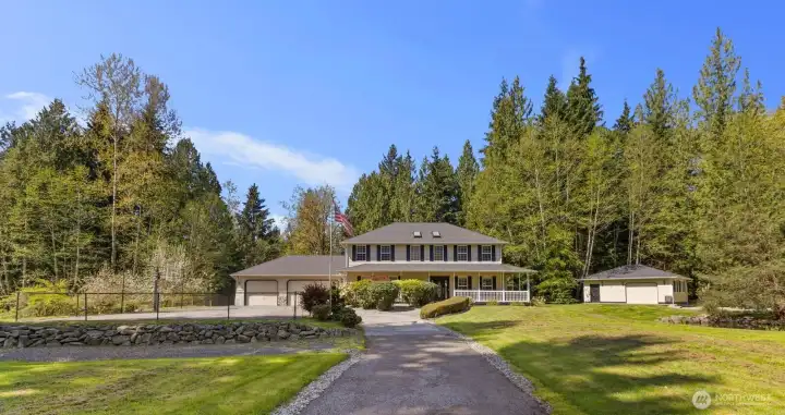 A sweeping manicured lawn and an expansive private driveway invite you up to the classic exterior of this charming home.