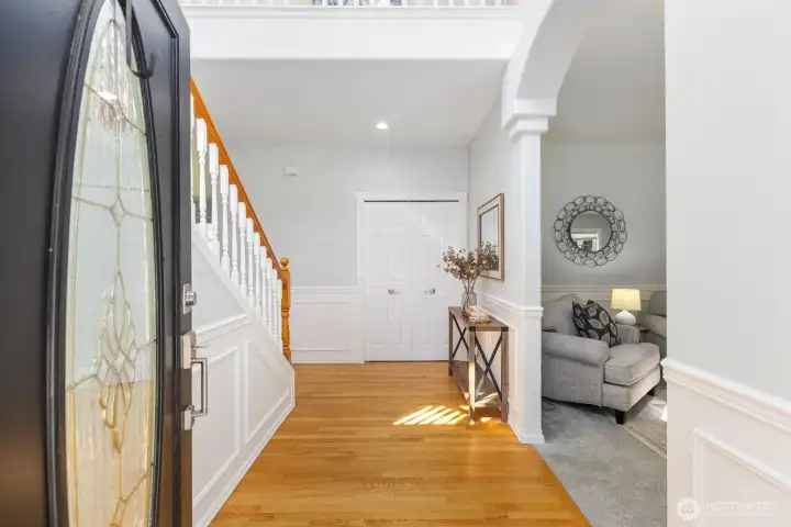 The bright and airy foyer welcomes you with gleaming hardwood floors, an elegant staircase, and beautiful arched entryways.