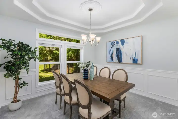 Host memorable dinners in the formal dining room, complete with classic wainscoting, a stunning tray ceiling, and a modern chandelier.