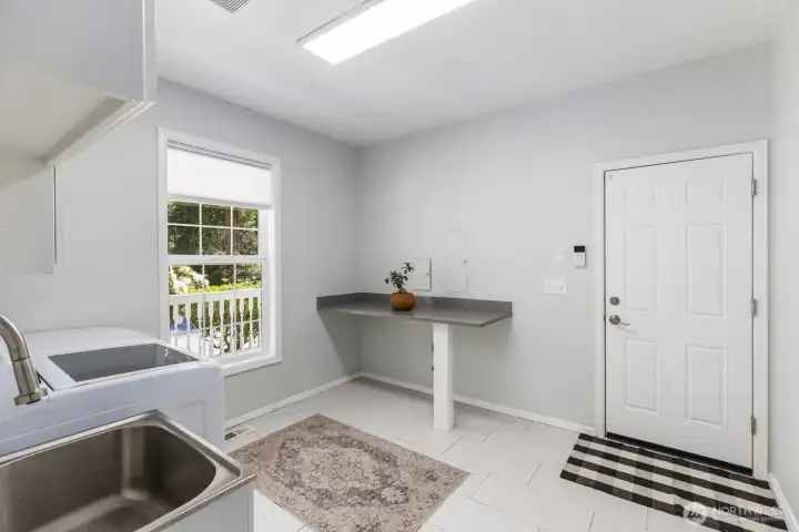 The dedicated laundry and mudroom offers a utility sink, practical folding counters, and direct exterior access to the garage for maximum convenience.