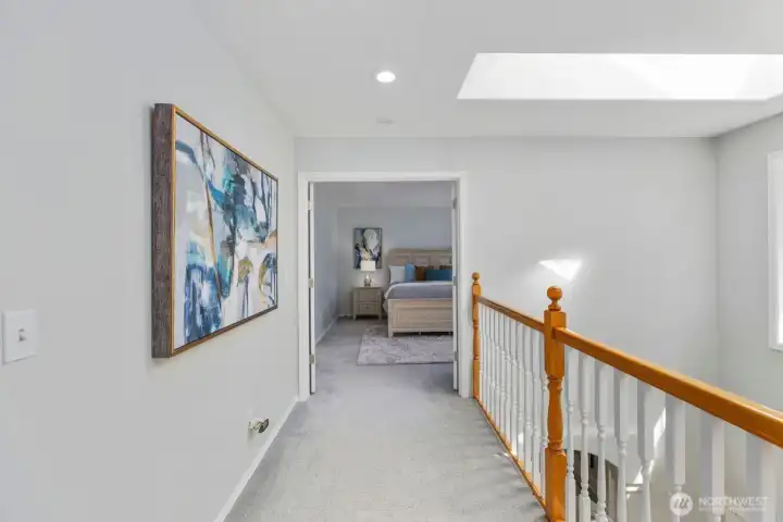 The bright and airy upper landing is bathed in natural light pouring in from a large, strategically placed skylight.