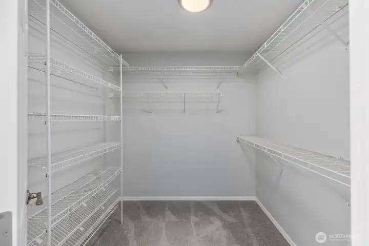 The massive primary walk-in closet provides exceptional storage space with built-in wire shelving and organization systems.