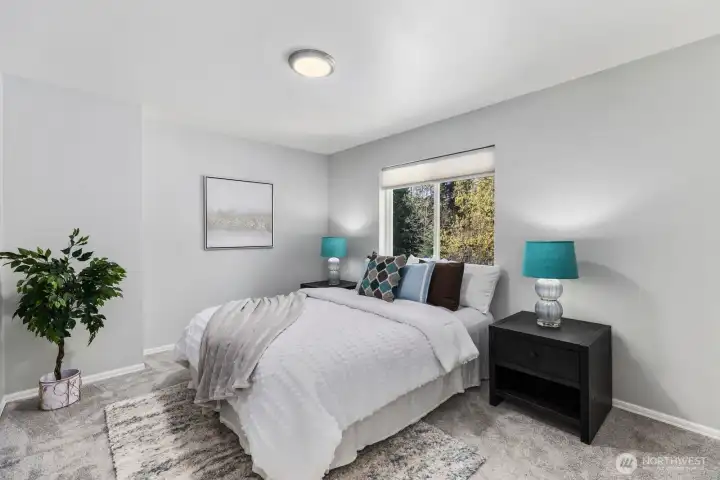 Another beautifully appointed bedroom offers ample space, comfortable carpeting, and large windows that invite the outside in.