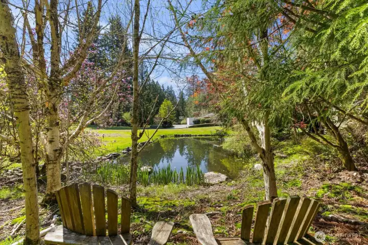 Enjoy quiet moments of reflection from the tranquil seating area overlooking the property's stunning, tree-lined private pond.