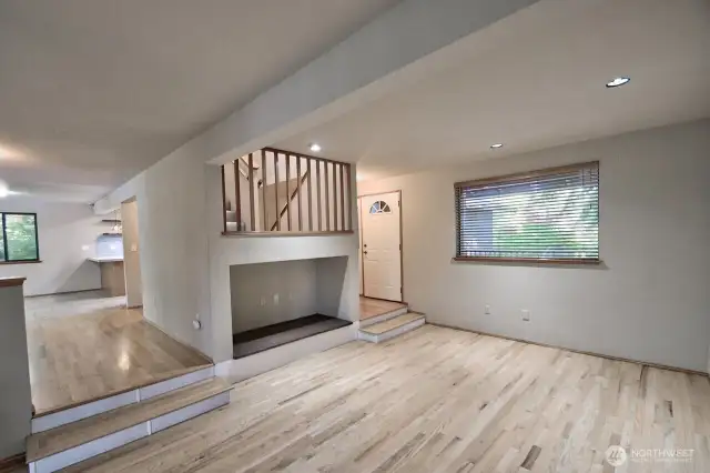 View of the living room looking toward the front door and dining room. Alcove with power and cable access for TV.