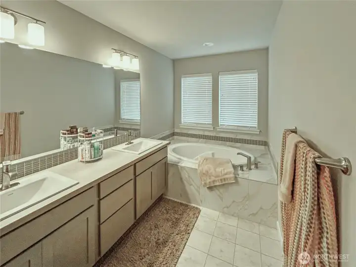 Luxury primary bath offers dual vanities, soaking tub, separate shower and private toilet room.