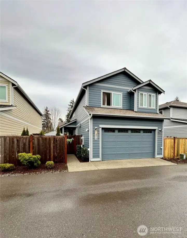 Rear view of home shows access to courtyard and 2 car garage.