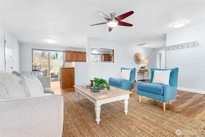 Living Room leads to kitchen, garage door on left, patio door straight back.