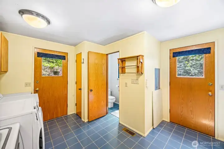 Laundry room with built in cupboards and half bath. Doors out to deck