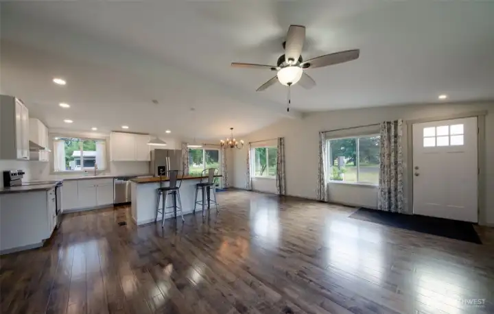 Open concept living area with seating on butcher block kitchen island.