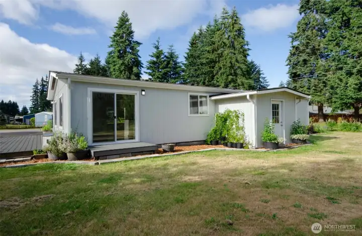 Back of home with entrance to kitchen and storage area/laundry room.