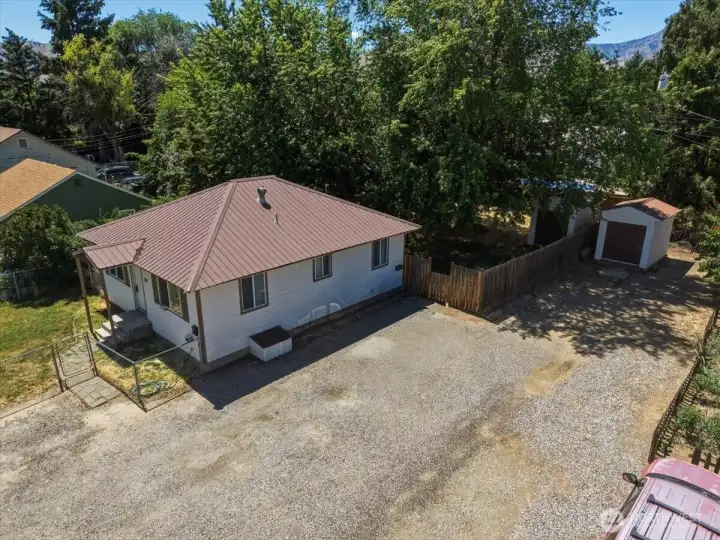 Metal roof and mature trees in the back yard.