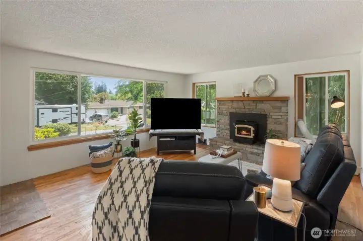 Large picture windows and wood burning fireplace.