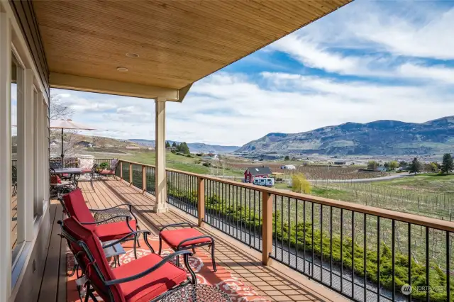 Sprawling deck extends across the back of a house, overlooking a breathtaking panorama of nature's beauty