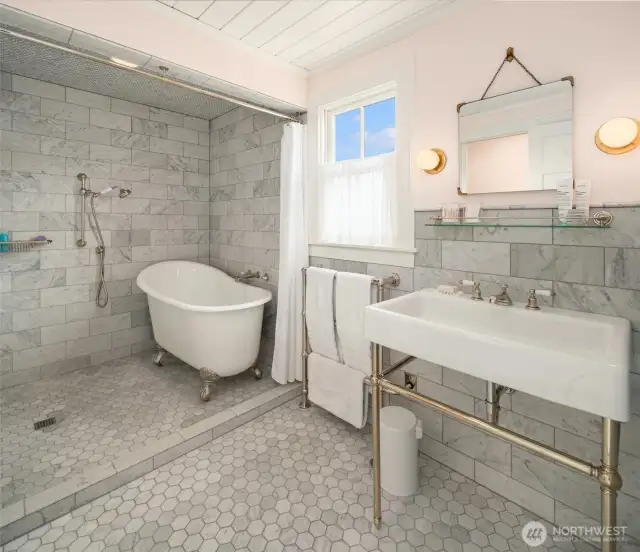 Spa-like serenity—Carrera marble, a cast-iron soaking tub, and luxurious finishes throughout.
