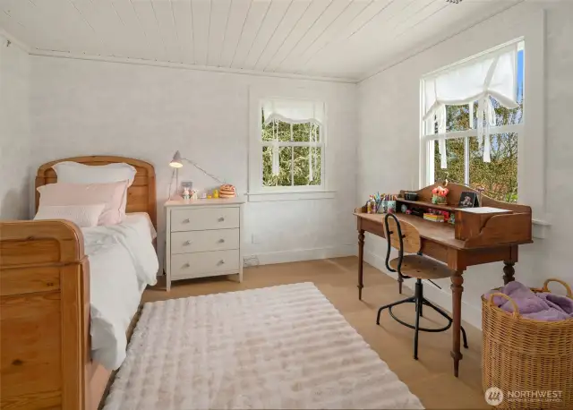 Comfort and style combine in this inviting second bedroom, offering versatility and tranquil views.