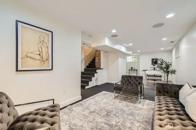 Another view of the lower level family room looking back at the stairs from the main floor and the game area beyond.