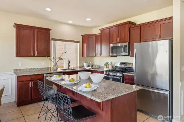 Island kitchen with rich wood cabinetry.