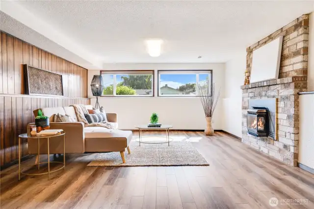 Downstairs, a spacious 2nd living room with another gas fireplace gets plenty of light from windows facing the front yard.