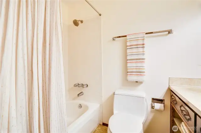 The full bath is finished with a tiled shower/tub surround, fresh paint, and new lighting.