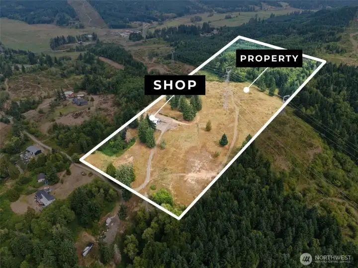 Rolling property with trees and open space on a hillside with a 40 x 48 shop connected to water and septic