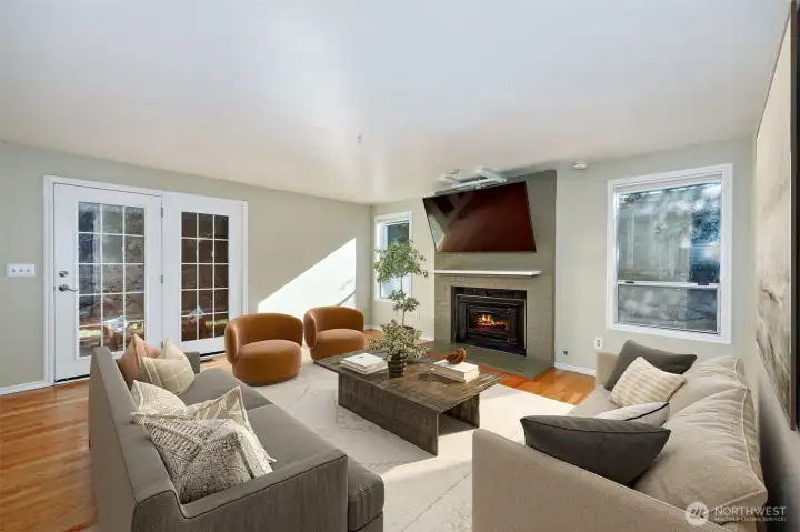 Family room with doors to fully fenced backyard and patio. Digitally staged (except for TV)