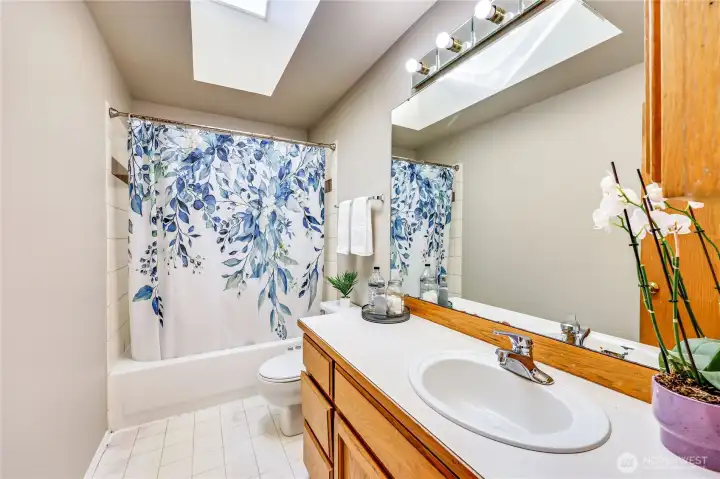 Full bath on second level, featuring skylight.
