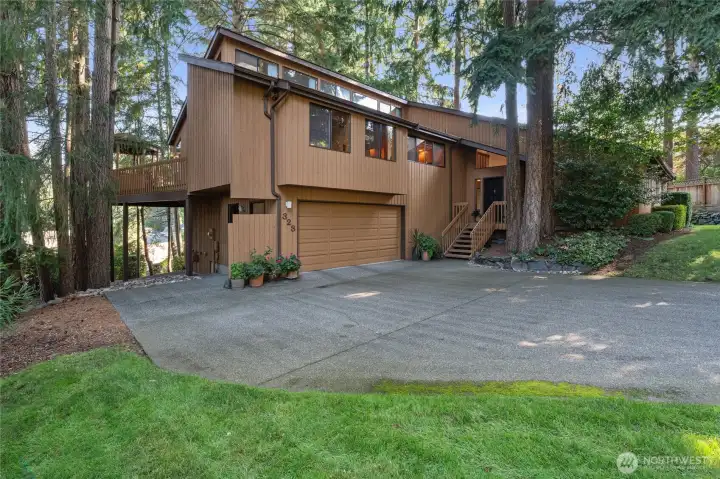 Striking NW Contemporary set among towering evergreens in Cormorant Passage, offering a warm, natural aesthetic and exceptional privacy. Elevated design showcases clean architectural lines, rich wood tones, and expansive windows that capture light and surrounding greenery. Welcoming entry, generous driveway, and oversized garage provide both function and curb appeal, while the setting creates a peaceful retreat just moments from the waterfront. Just minutes to the Ferry and Saltar's Point.