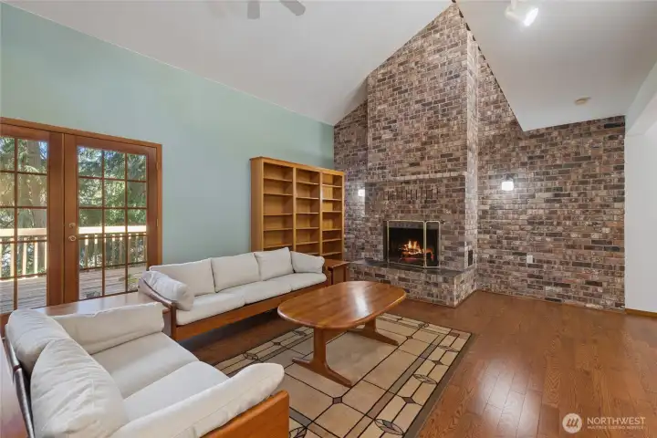 Dramatic floor-to-ceiling brick fireplace serves as a striking focal point, adding warmth and architectural character.