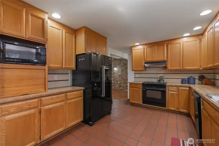 Spacious kitchen with abundant cabinetry, generous counter space, and a large window overlooking the natural surroundings.