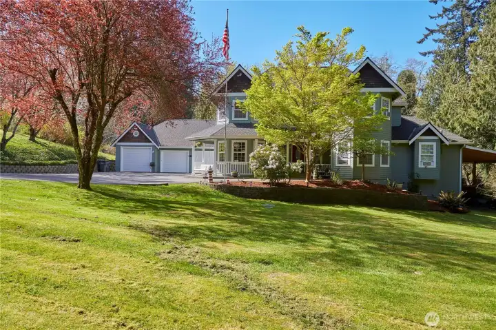 Front view of home. Wrap around porch with porch swing and beautiful landscaping.