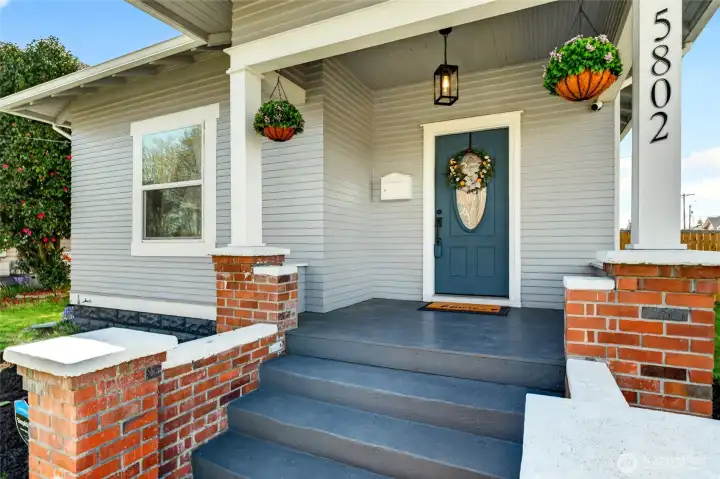 Beautiful front porch of fully updated, 4 bedroom, 2.5 bath on a corner lot with fenced yard.