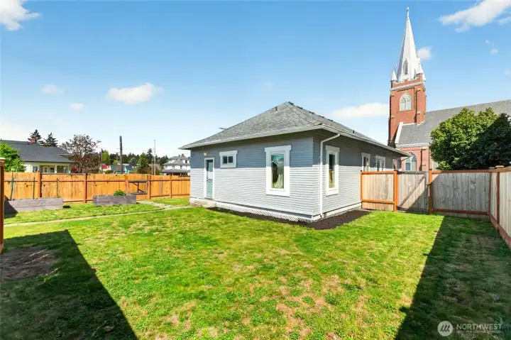 Fully fenced backyard with raised garden beds and Shed.