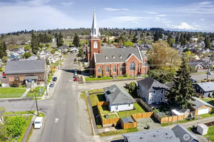 Aerial view of beautiful, fully updated, 4 bedroom, 2.5 bath on a corner lot with fenced yard next to a stunning church.