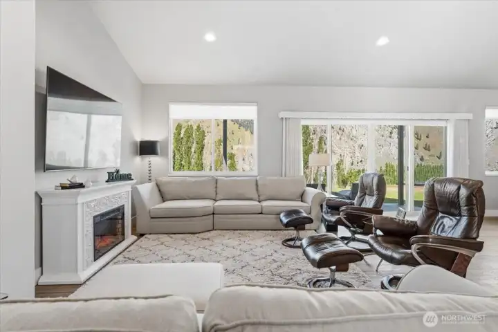 Living area with large windows and sliding glass doors out to backyard