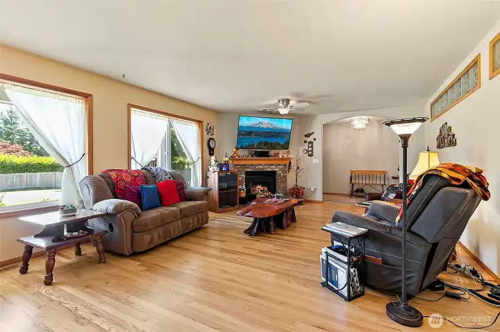 Formal living room with hardwood floors, natural lighting, ceiling fan and plenty of seating options for larger sized furniture.