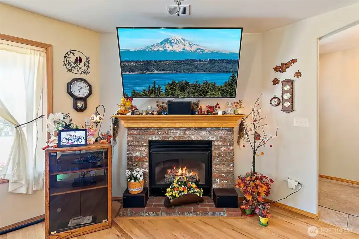Cozy gas fireplace with brick hearth surround keeps those cooler winter nights warm.