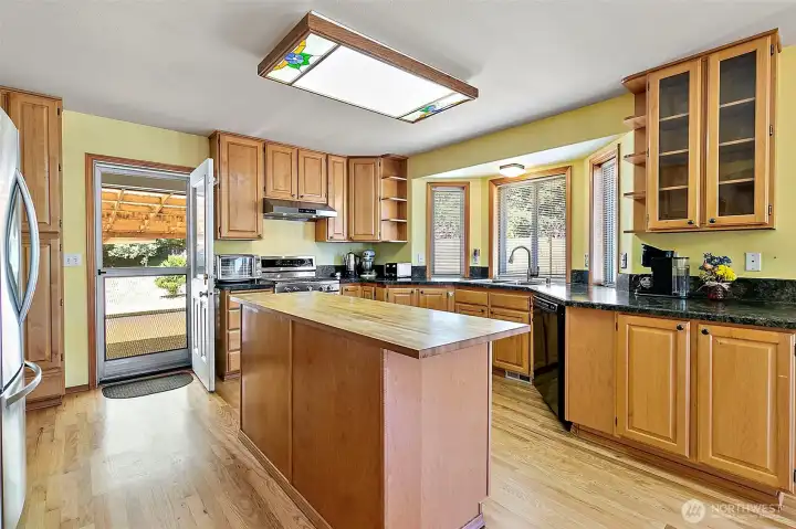 Good sized kitchen with room for two chefs- gas cooktop, butcher block island, bay window overlooking the backyard and door leading out to the massive sized covered patio. No more BBQing in the rain!