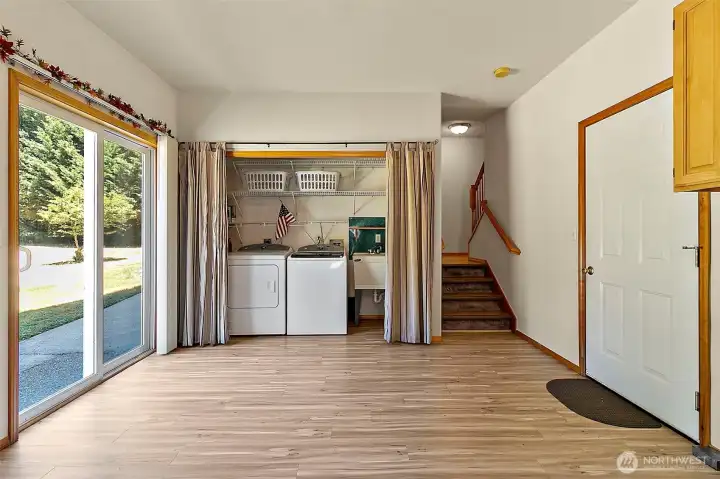 Lower lever family room with laundry and deep sink nicely tucked away. Door leads out to the 3 car garage.