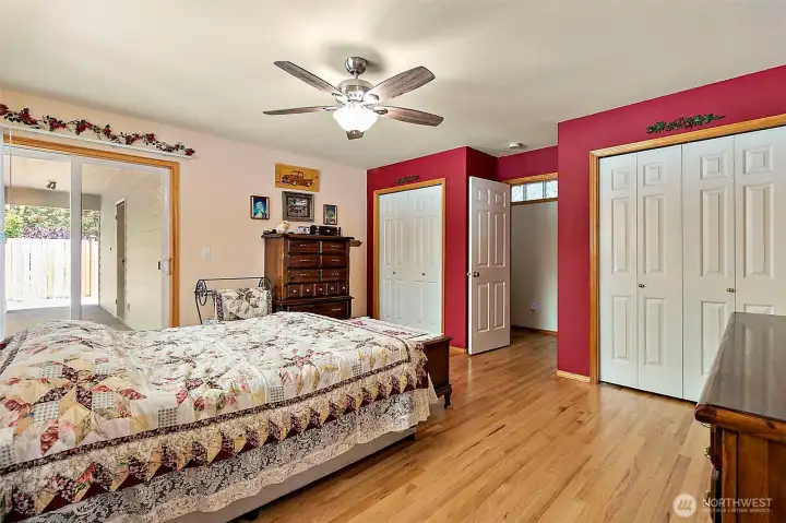 Nice sized primary suite with double closets, hardwood floors and sliding glass door out to the covered patio.