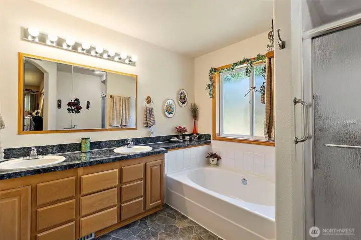 Primary 5 piece bathroom with soaking tub, double sink vanity and walk-in shower.