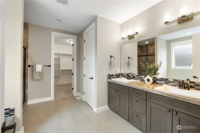 Primary suite bath with dual vanities soaking tub and large walk in closet