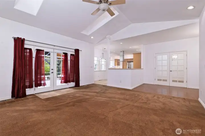 Another shot of the living room, with the dining room doors on the right, and the leading into the kitchen in the middle, and French doors leading out to the back deck on the right.