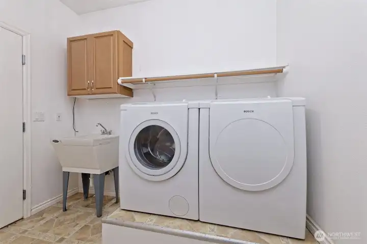 Nice utility room with Bosch washer and dryer set, and a nice deep sink.