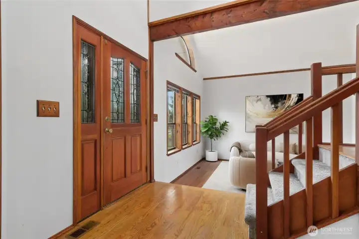 Vaulted entry with extensive hardwood flooring