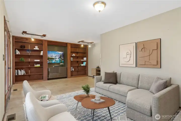 Lg family room with entertainment center, shelving on both sides. French doors off to patio in rear yard.