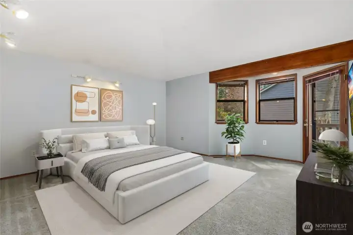 Primary bedroom with bay windows, glass door out to large deck.
