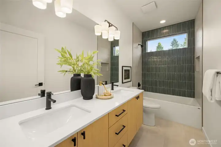 Upstairs full bath with custom tile and vanities.