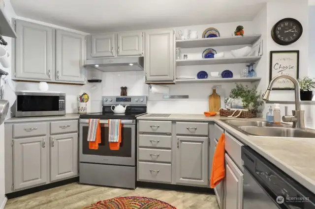 Charming kitchen with gray cabinets & open shelving for a modern look.